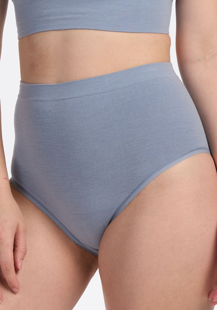 A person models the Woolx Mabel Full Coverage Underwear in Bluebell, shown from mid-thigh to just below the chest on a plain background, highlighting the style and comfort of this seamless underwear.