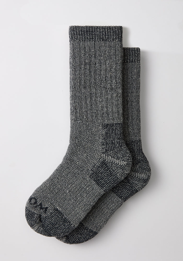 A pair of Woolx Mens Extreme Crew Socks in Charcoal Heather laid flat on a white surface.