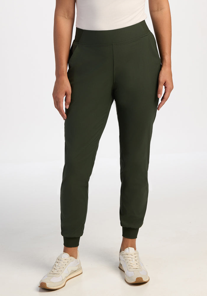 Model wears Woolx Palmer Petite Joggers in Duffel Bag with a white top and sneakers, standing against a plain background.